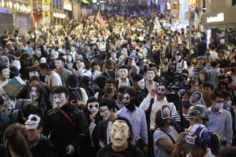 Maskierte Demonstranten versammeln sich auf einer Straße in Hongkong.