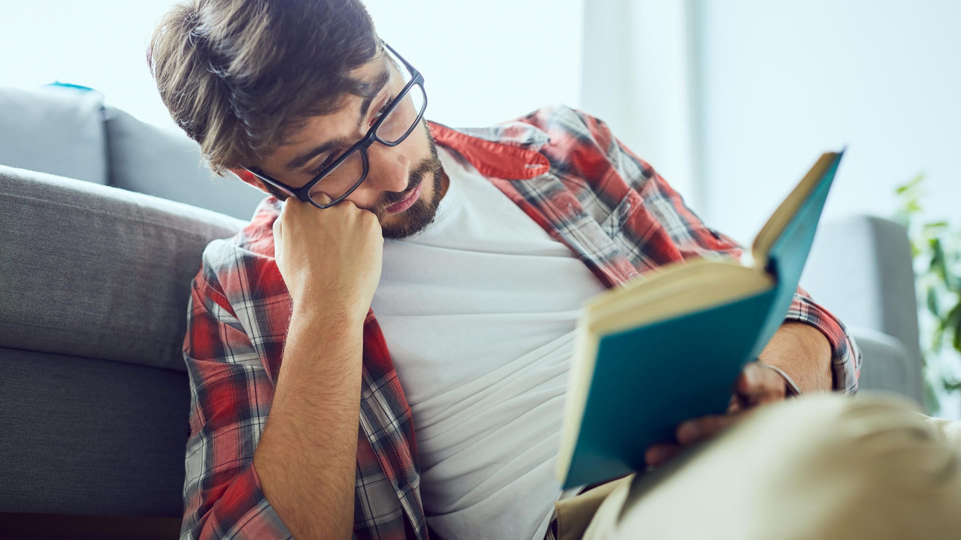 Ein Mann liest ein Buch: Ausreichende Beleuchtung ist wichtig, um die Augen zu schonen.