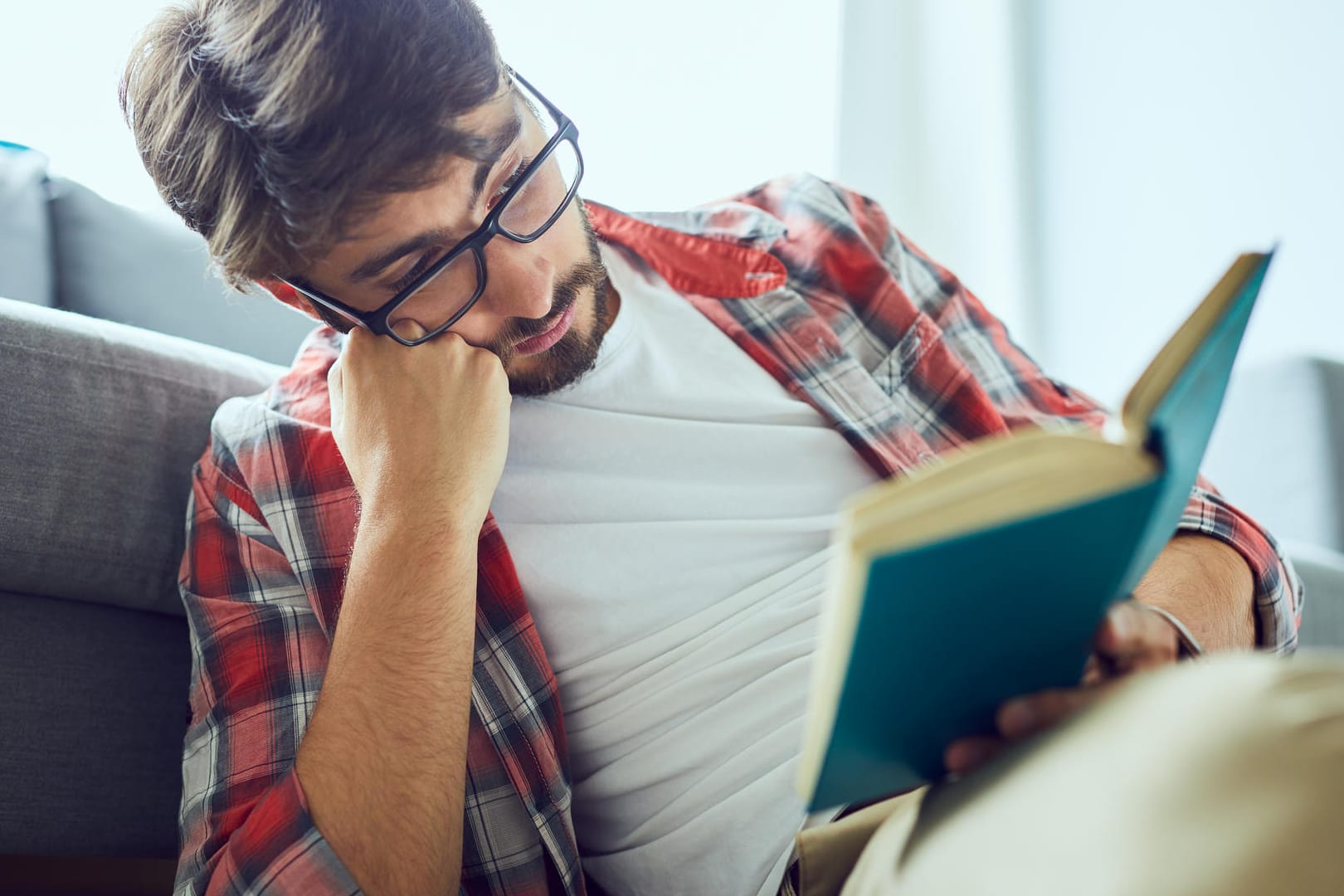 Ein Mann liest ein Buch: Ausreichende Beleuchtung ist wichtig, um die Augen zu schonen.