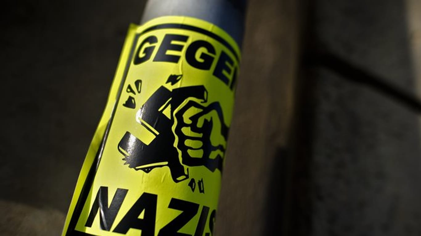 Ein Aufkleber "Gegen Nazis" klebt an einem Straßenschild in Dresden.