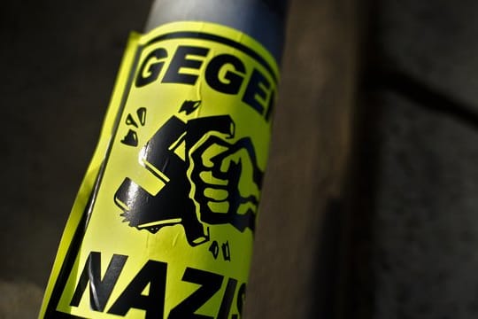 Ein Aufkleber "Gegen Nazis" klebt an einem Straßenschild in Dresden.