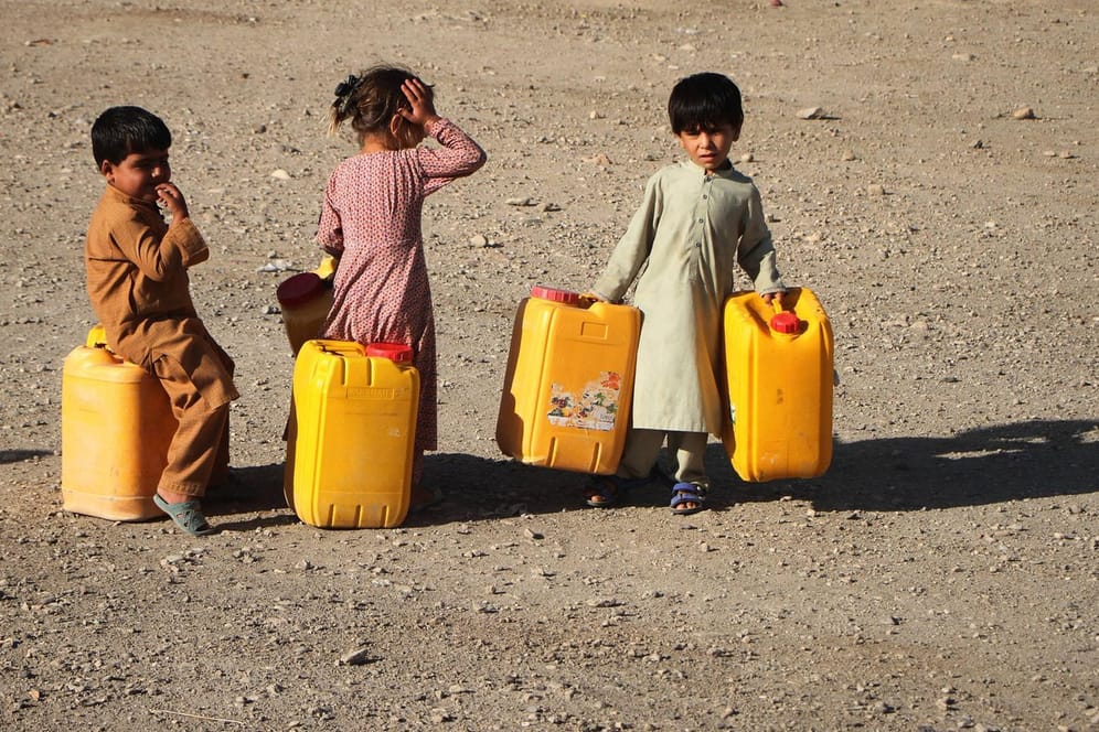Afghanische Kinder holen Wasser an einem Brunnen: Nach jahrelangen Kämpfen ist das Land von Landminen, nicht explodierten Granaten und Raketen übersät.(Symbolbild)