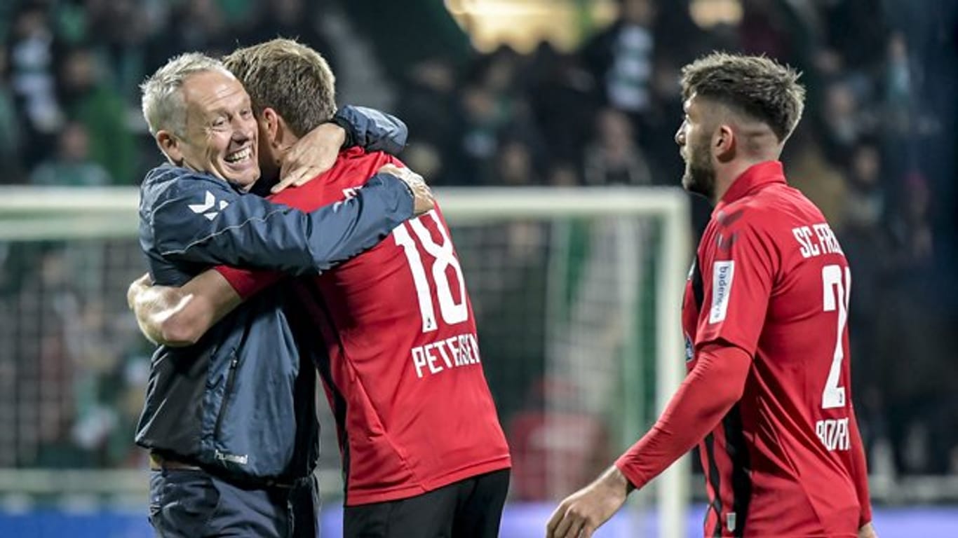 Freiburgs Coach Christian Streich gratuliert seinem Doppeltorschützen Nils Petersen.