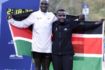 Die Kenianer Geoffrey Kamworor und Joyciline Jepkosgei posieren während der Siegerehrung mit den Landesfarben.