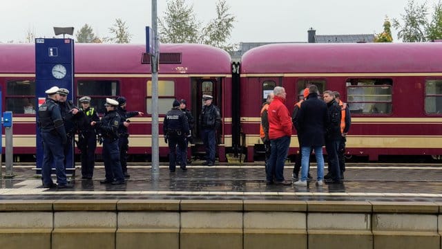 Poizisten und Reisende stehen am Freitag neben dem Partyzug, nachdem er in Greven gestoppt wurde. Poizisten und Reisende stehen am Freitag neben dem Partyzug, nachdem er in Greven gestoppt wurde.