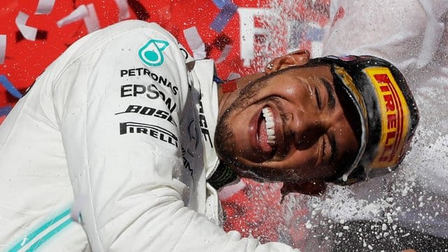 Lewis Hamilton genießt nach seinem sechsten WM-Titel die Champagnerdusche.