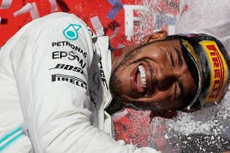Lewis Hamilton genießt nach seinem sechsten WM-Titel die Champagnerdusche.