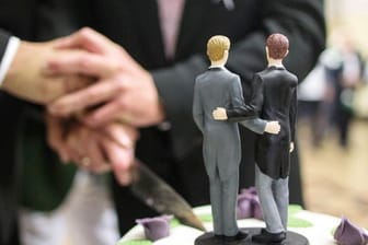 Ehe für Alle: Zwei Männer schneiden nach ihrer Eheschließung eine Hochzeitstorte an.