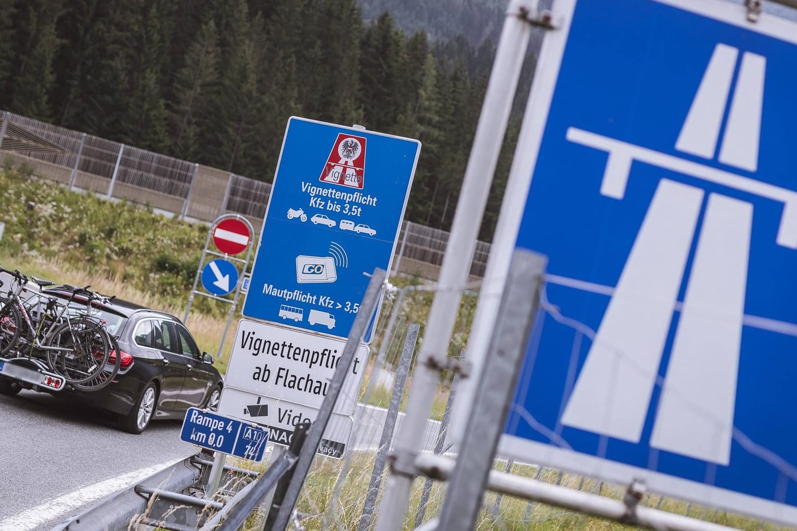 Autobahnschild und Vignettenpflichtschild bei einer Autobahnauffahrt: Auf bestimmten Streckenabschnitten in Österreich wird unabhängig von den Vignetten eine Sondermaut fällig.