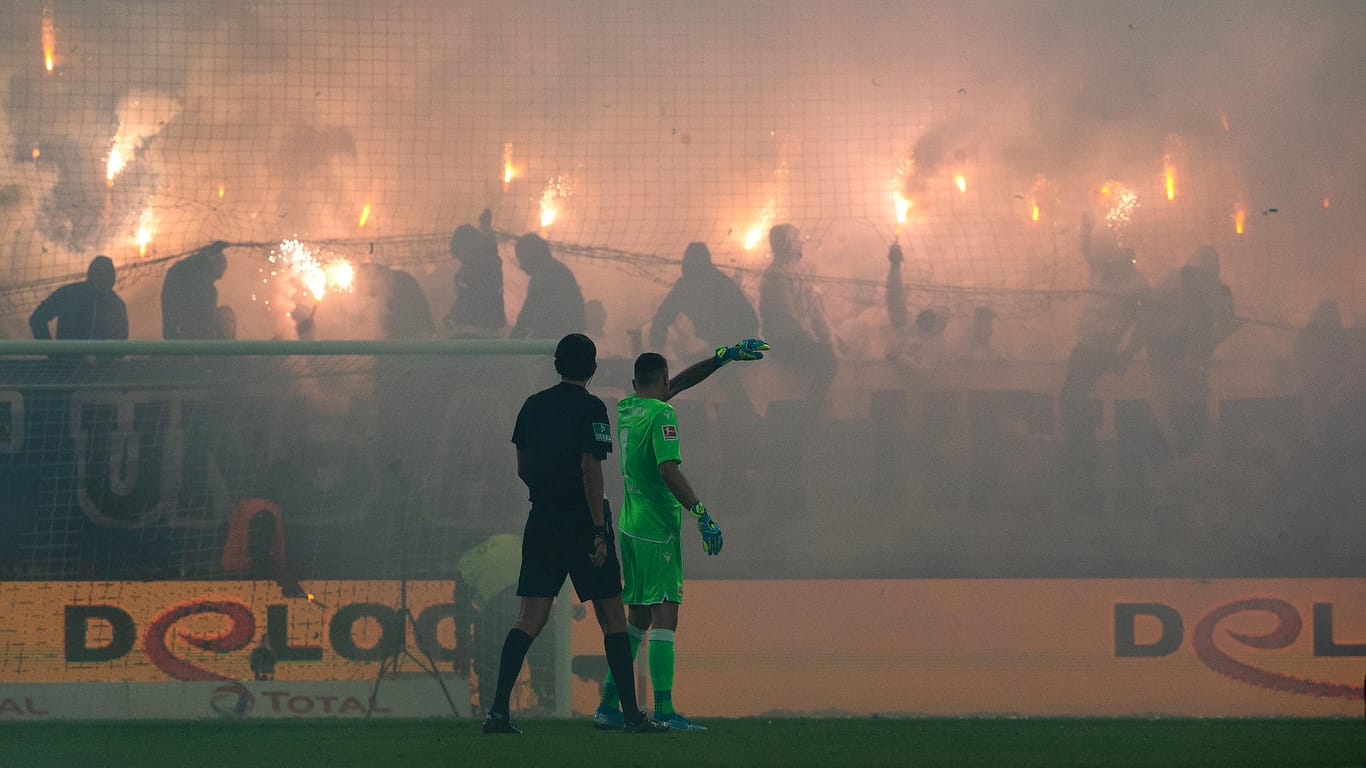 Sorgten mit Pyro und Raketenbeschuss auf Union-Fans für Chaos: Die Hertha-Ultras vor Union-Torhüter Gikiewicz (grünes Trikot) und Schiedsrichter Deniz Aytekin (schwarzes Trikot).