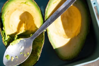 Ein Löffel liegt über einer Avocado: Im Jahr 2018 wurden rund 94.000 Tonnen der fettreichen, grünen Früchte nach Deutschland importiert.