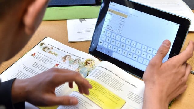 Ein Schüler arbeitet in der Waldschule in seinem Klassenzimmer am Tablet. Ein Schüler arbeitet in der Waldschule in seinem Klassenzimmer am Tablet.