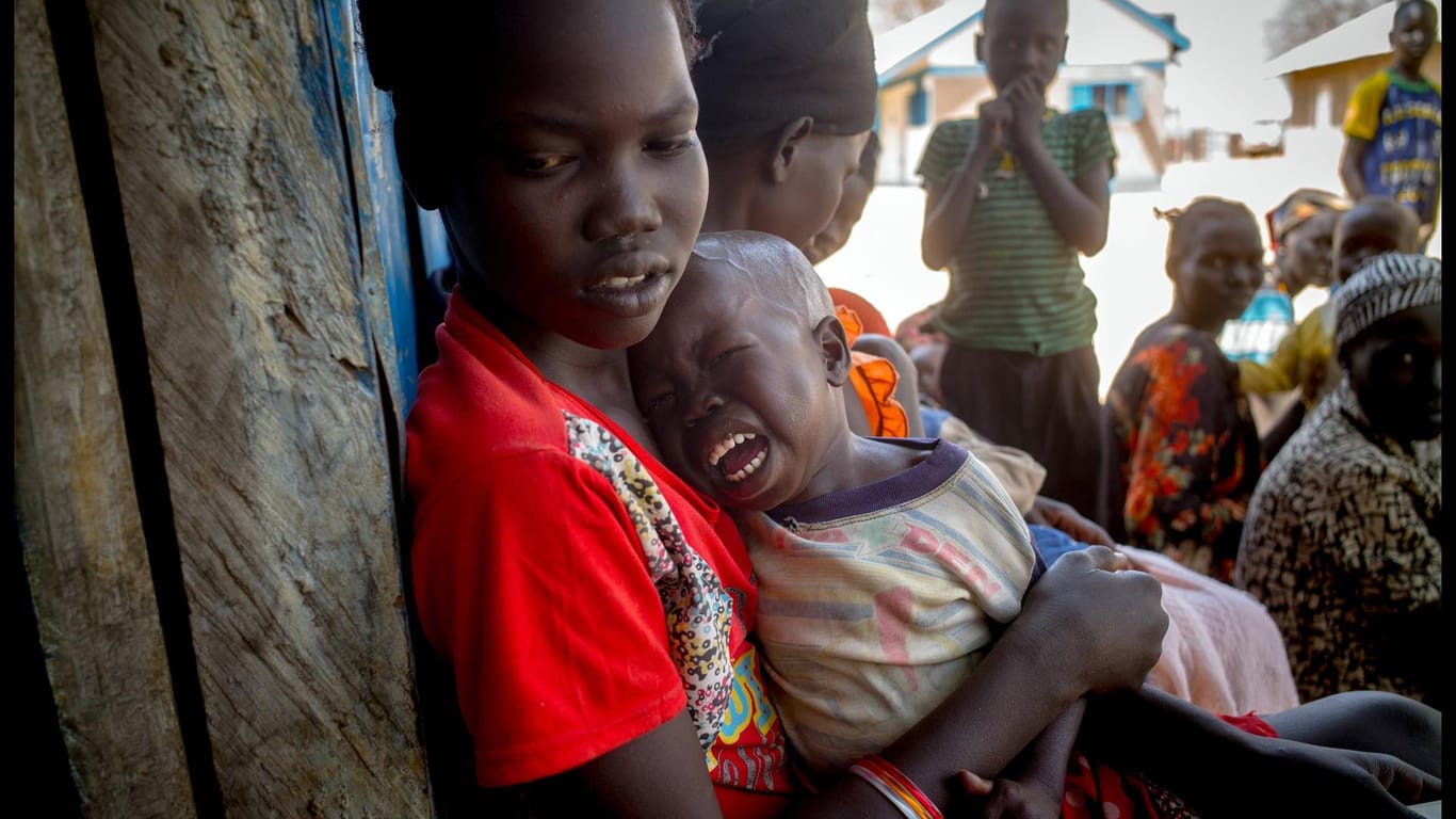 Eine Mutter mit ihrem unterernährten Kind auf dem Weg zu einer Versorgungsstelle im Südsudan.