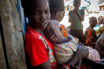 Eine Mutter mit ihrem unterernährten Kind auf dem Weg zu einer Versorgungsstelle im Südsudan.