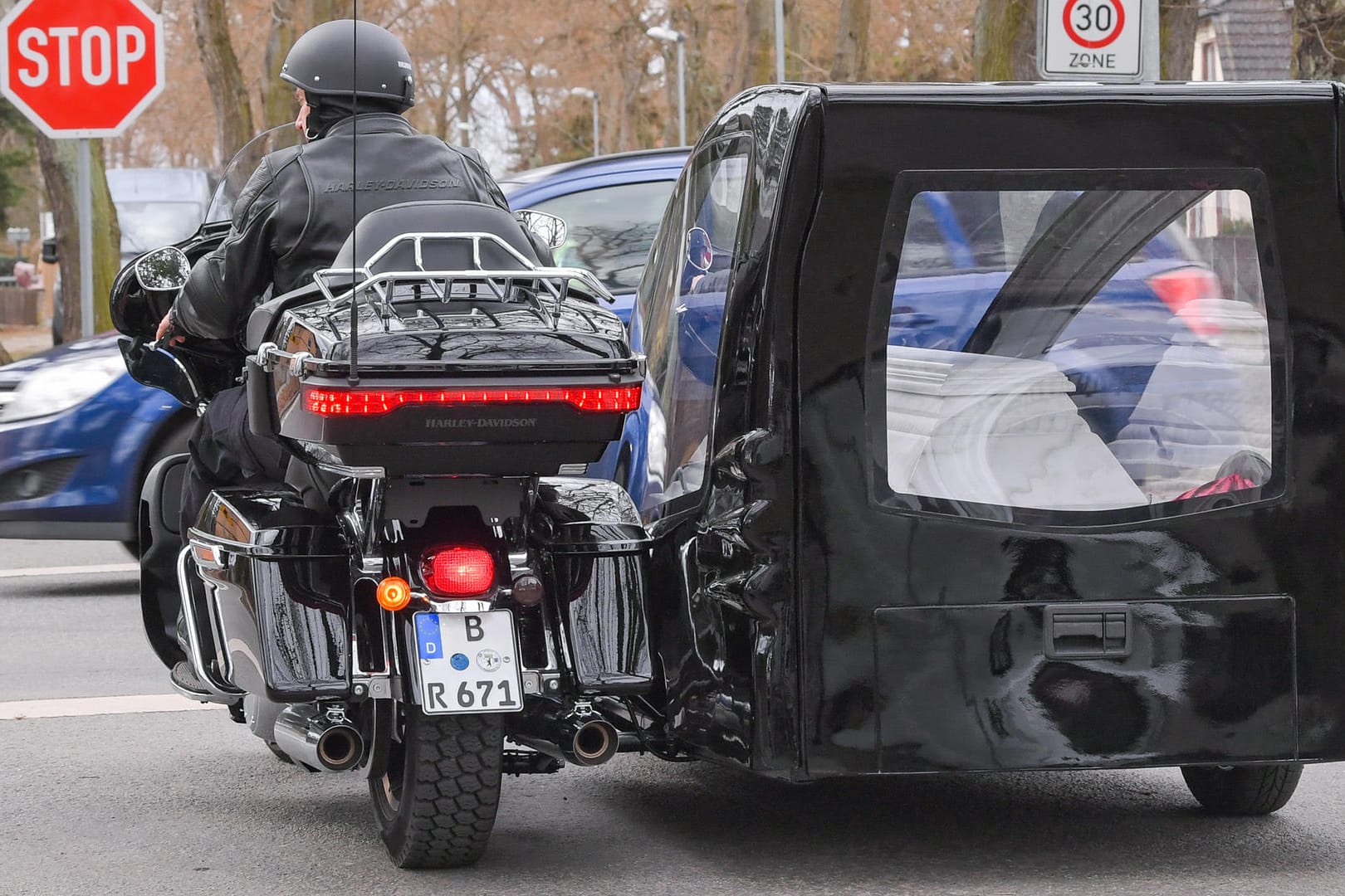 Bestatter Ingo Rauf fährt mit seinem Motorrad der Marke "Harley Davidson" mit Beiwagen, in dem ein Sarg liegt, über eine Straße: Individuelle Beisetzungen liegen im Trend. See- oder Friedwald-Bestattungen häufen sich und auch der Weg zur letzten Ruhe erfolgt längst nicht mehr nur traditionell.