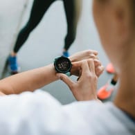 Eine Frau schaut auf ihre Uhr: Wer einmal wöchentlich läuft, hat bereits ein niedrigeres Sterberisiko, sagen Forscher.