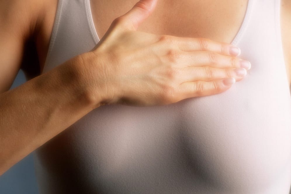 Eine Frau fasst an ihre Brust: In Deutschland erkranken jährlich etwa 70.000 Frauen an Brustkrebs.
