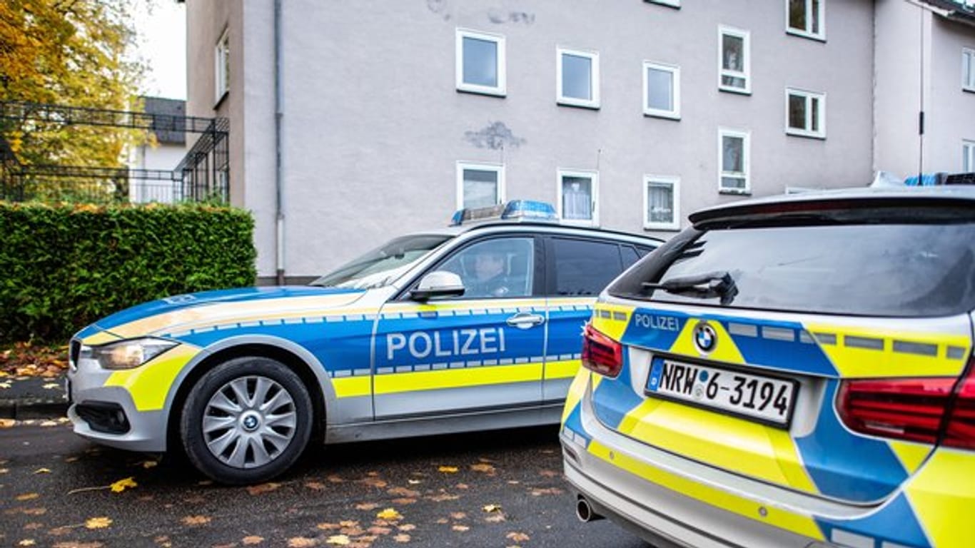 Polizeifahrzeuge vor dem Mehrfamilienhaus in Detmold, in dem eine 15-Jährige ihren dreijährigen Halbbruder erstochen haben soll.