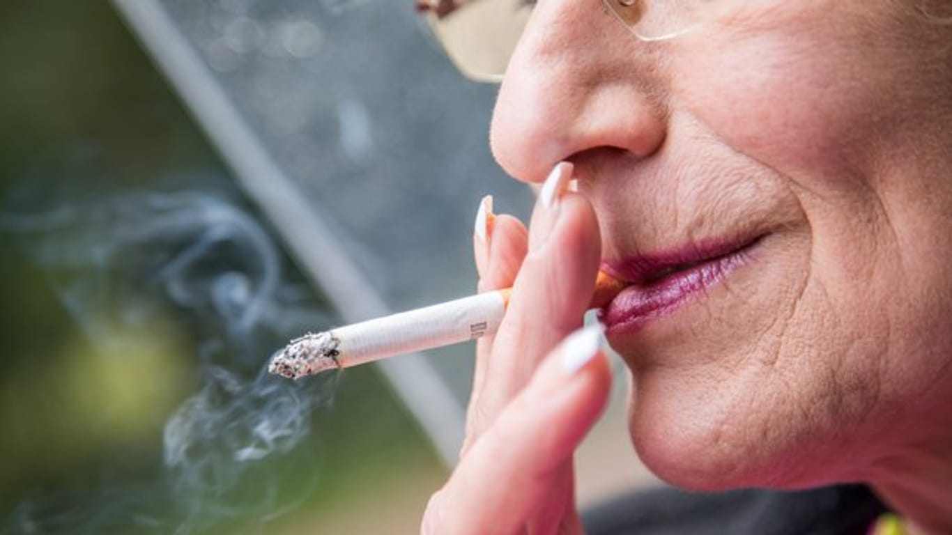 Frau raucht Zigarette: Hören Senioren mit dem Rauchen auf, sinkt zum Beispiel das Herzinfarktrisiko. (Symbolbild)