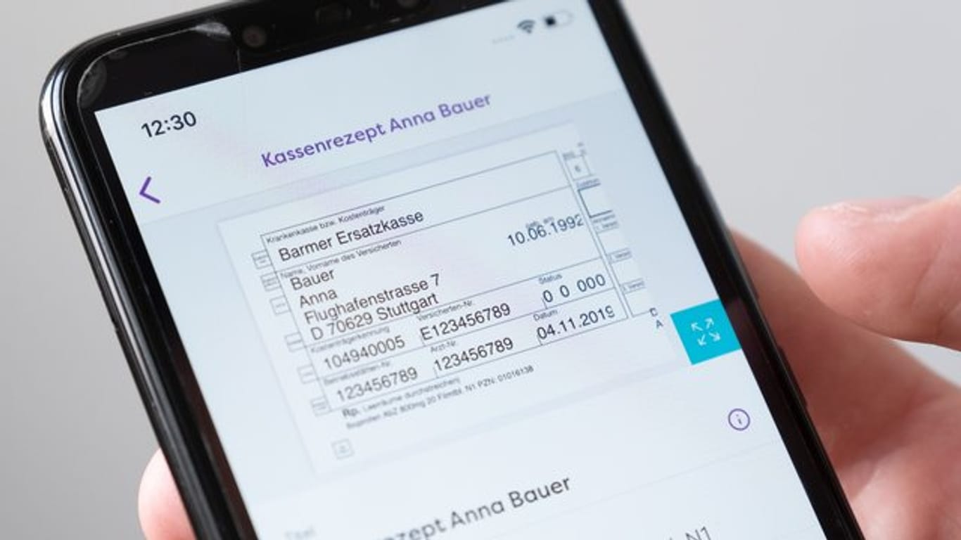 Auf einem Smartphone wird in einer App ein digitales Rezept einer fiktiven Patientin dargestellt.