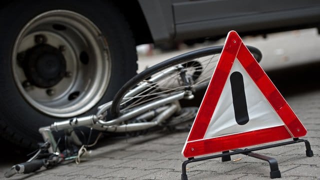 Ein zerstörtes Fahrrad unter den Hinterrädern eines Lkw. Ein zerstörtes Fahrrad unter den Hinterrädern eines Lkw.