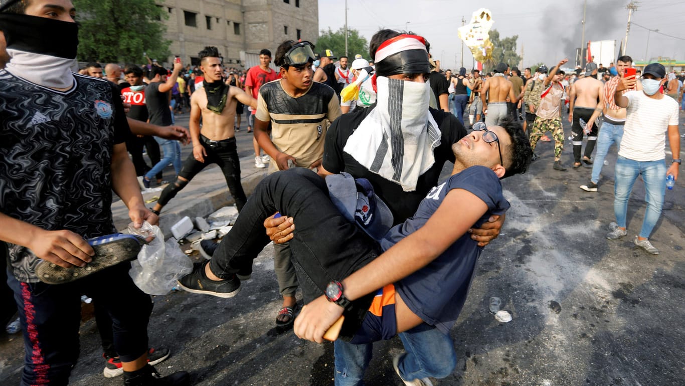 2. Oktober in Bagdad: Ein Demonstrant trägt einen verletzten jungen Mann. Schon in einer frühen Phase der Proteste waren Scharfschützen zum Einsatz gekommen.