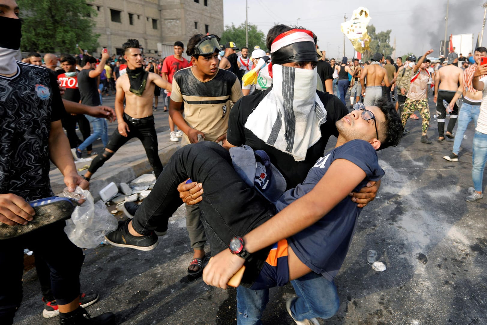 2. Oktober in Bagdad: Ein Demonstrant trägt einen verletzten jungen Mann. Schon in einer frühen Phase der Proteste waren Scharfschützen zum Einsatz gekommen.