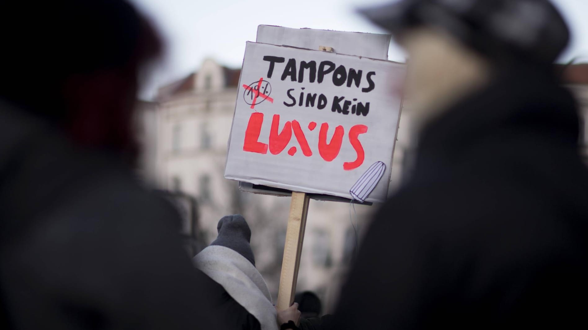 Ein Protestplakat gegen die Luxussteuer auf Damenhygiene-Artikel: Der ermäßigte Mehrwertsteuersatz von 7 Prozent ist für wichtige Güter des täglichen Bedarfs vorgesehen. Damenhygiene-Artikel gehören jetzt dazu.