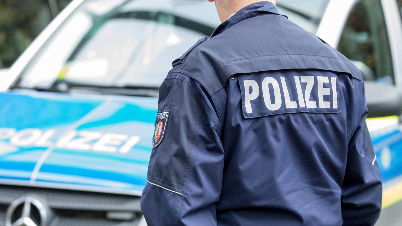 Polizist vor einem Streifenwagen: Die Duisburger Ermittler bitten um Hinweise aus der Bevölkerung – auch um mögliche Geschwister von Mia zu schützen (Symbolbild).