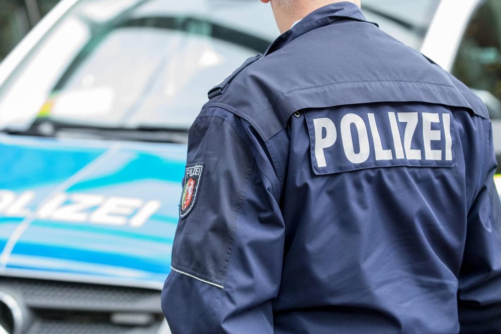 Polizist vor einem Streifenwagen: Die Duisburger Ermittler bitten um Hinweise aus der Bevölkerung – auch um mögliche Geschwister von Mia zu schützen (Symbolbild).