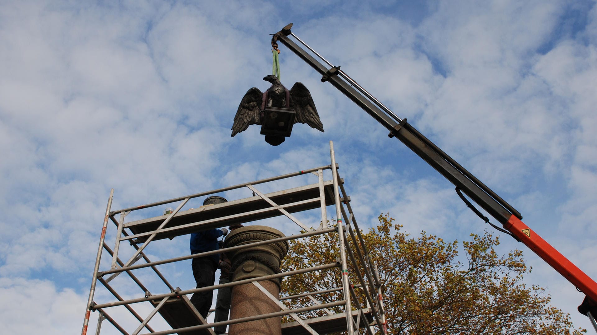 Der Mengender Adler wird mit einem Kran auf das Kriegerdenkmal gehoben: Das Denkmal wurde 2014 im Sturm "Ela" zerstört. Der Mengender Adler wird mit einem Kran auf das Kriegerdenkmal gehoben: Das Denkmal wurde 2014 im Sturm "Ela" zerstört.