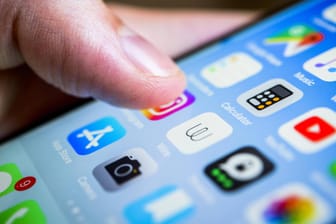 Finger berühren das Display von einem iPhone Smartphone Homescreen viele app Icons auf dem Displa