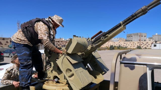 Ein Regierungssoldat inspiziert die Waffen eines Militärfahrzeugs. Ein Regierungssoldat inspiziert die Waffen eines Militärfahrzeugs.