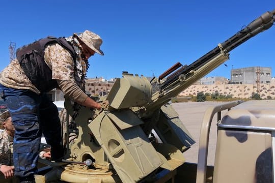 Ein Regierungssoldat inspiziert die Waffen eines Militärfahrzeugs.