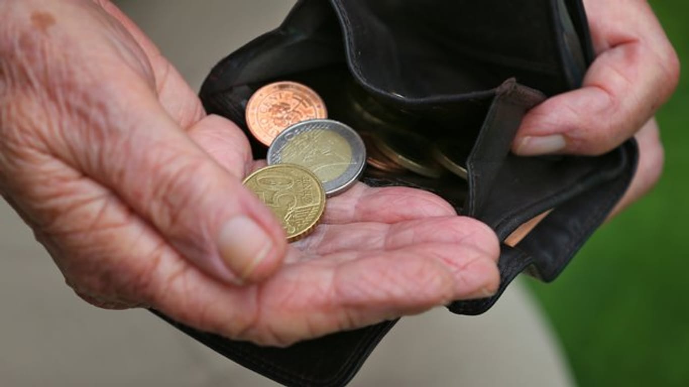 Eine Rentnerin hält einen Geldbeutel mit verschiedenen Euromünzen.
