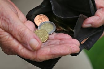 Eine Rentnerin hält einen Geldbeutel mit verschiedenen Euromünzen.