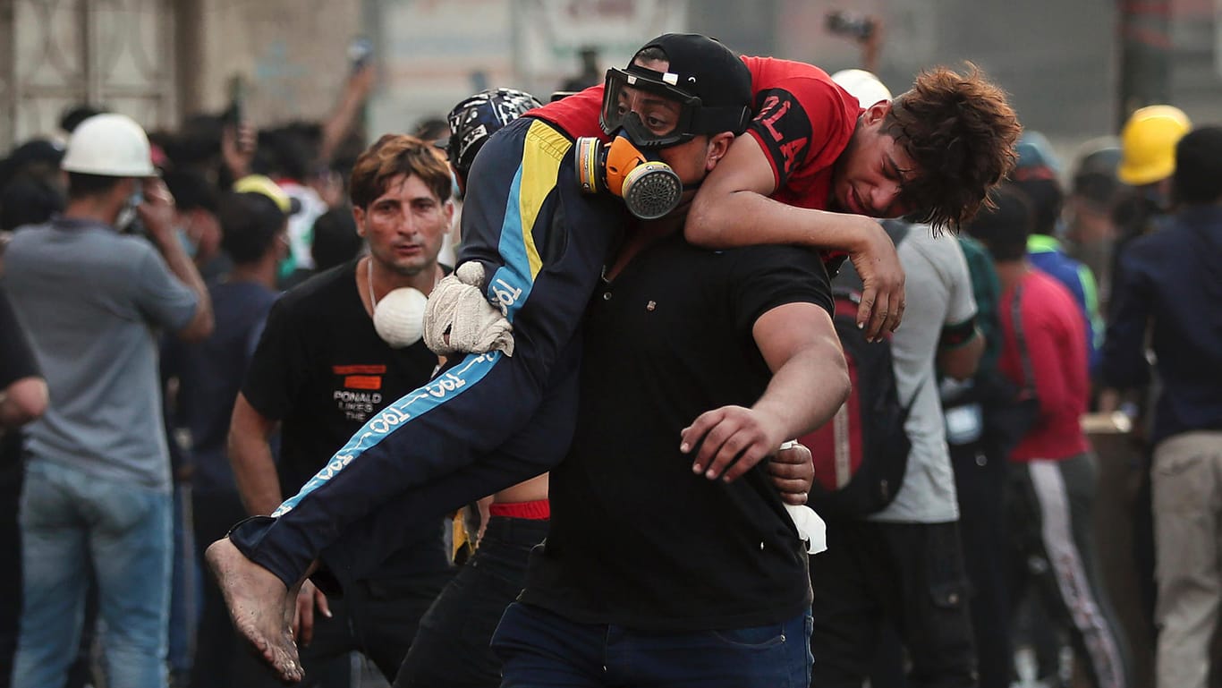 Ein verletzter Demonstrant wird von der Straße getragen: Am Samstag gingen Sicherheitskräfte mit großer Härte gegen den Protest in Bagdad vor.