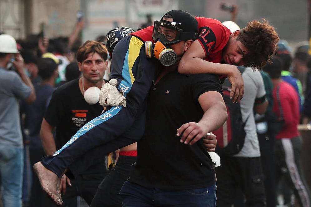 Ein verletzter Demonstrant wird von der Straße getragen: Am Samstag gingen Sicherheitskräfte mit großer Härte gegen den Protest in Bagdad vor.
