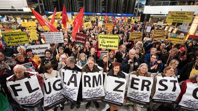 Kundgebungsteilnehmer stehen mit Plakaten im Terminal Kundgebungsteilnehmer stehen mit Plakaten im Terminal