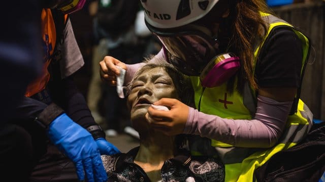 Ein Obdachloser wird von medizinischen Helfern behandelt, nachdem er während einer Demonstrationen von Tränengas getroffen wurde. Ein Obdachloser wird von medizinischen Helfern behandelt, nachdem er während einer Demonstrationen von Tränengas getroffen wurde.