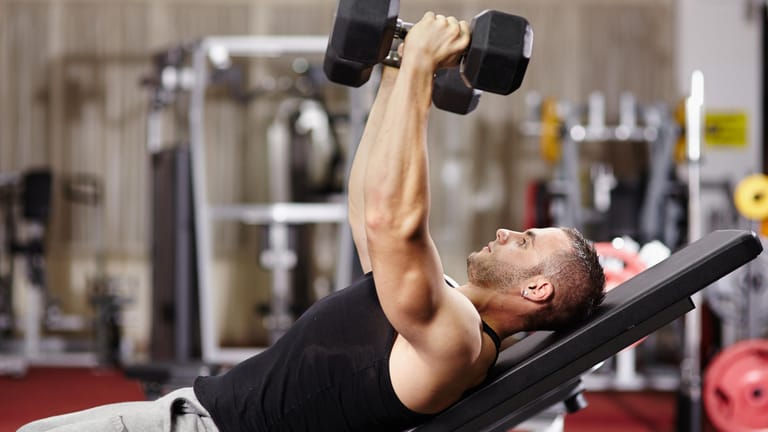 Ein Mann beim Krafttraining: Es stabilisiert das Skelett und trainiert die Kraft.