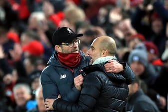 Liverpools Trainer Jürgen Klopp (l) und Man-City-Coach Pep Guardiola umarmen sich nach dem Abpfiff.