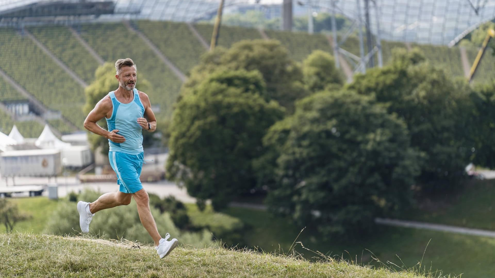 Ein Mann joggt im Olympiapark: Die Parkanlage wurde anlässlich der Olympischen Spiele 1972 errichtet.