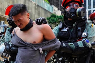 Ein Polizist mit Gasmaske führt einen Demonstranten in Hongkong ab: Nach dem Tod eines Studenten eskaliert die Gewalt auf den Straßen erneut.