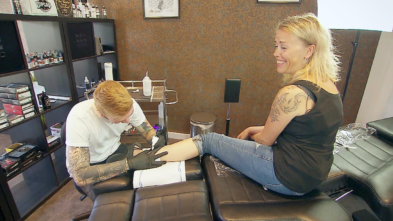 Bianca im Tattostudio: Sie ließ sich das Wort "Moments" an den Knöchel stechen, Thomas entschied sich für eine Stelle am oberen Rücken.