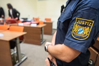 Ein Justizbeamter zu Beginn des Prozesses im Sitzungssaal vom Landgericht München II.
