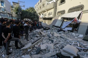 Anwohner und Passanten stehen nach dem israelischen Luftangriff vor dem beschädigte Haus von Baha Abu Al Ata.