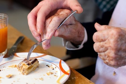Ein junger Mann, der ein Freiwilliges Soziales Jahr (FSJ) absolviert, hilft einer Bewohnerin in einer Wohngemeinschaft für Demenzkranke. Ein junger Mann, der ein Freiwilliges Soziales Jahr (FSJ) absolviert, hilft einer Bewohnerin in einer Wohngemeinschaft für Demenzkranke.