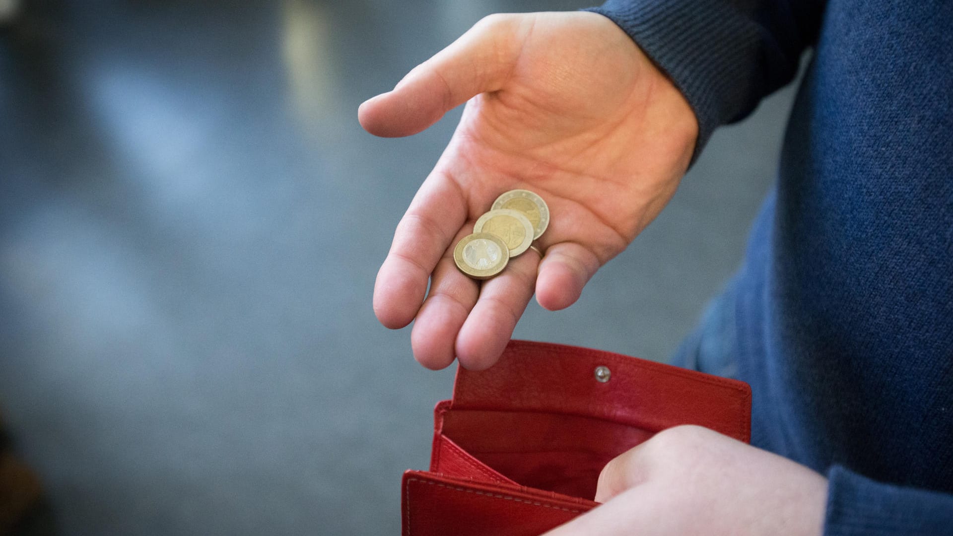 Ein Mann hält Münzen in der Hand: Arbeitnehmer haben Anspruch auf Hartz-IV-Leistungen, wenn ihr Einkommen zu niedrig ist.