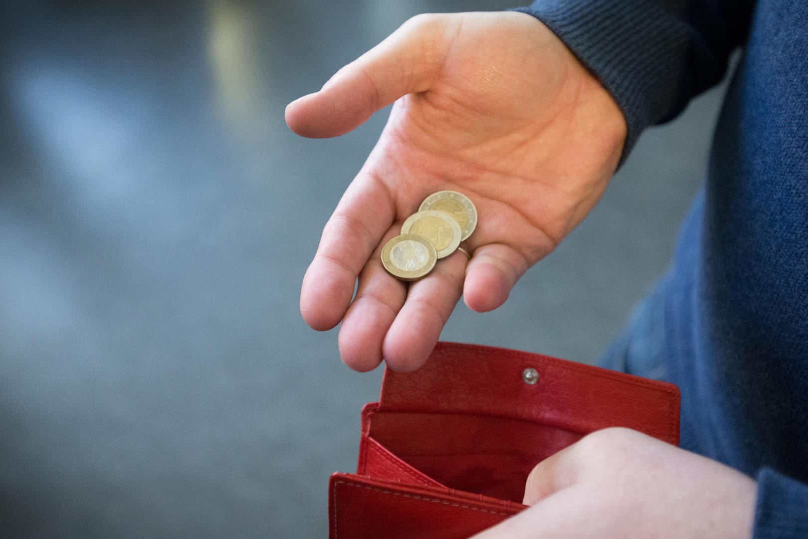 Ein Mann hält Münzen in der Hand: Arbeitnehmer haben Anspruch auf Hartz-IV-Leistungen, wenn ihr Einkommen zu niedrig ist.